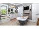 A modern bathroom featuring a soaking tub, tiled floor, single sink, and a television at 447 Lacy Rd, Canton, GA 30115