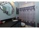 This bathroom includes dark granite counters, a patterned shower curtain, and vintage mirror at 447 Lacy Rd, Canton, GA 30115