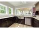Bright and airy kitchen showcasing dark cabinets, granite counters, a stainless steel sink, and a breakfast bar at 447 Lacy Rd, Canton, GA 30115