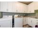 Well-organized laundry room featuring white cabinets, granite countertops, and modern washer and dryer at 447 Lacy Rd, Canton, GA 30115