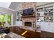 Cozy living room features a brick fireplace, built-in bookshelves, and double doors to the outdoor seating area at 447 Lacy Rd, Canton, GA 30115