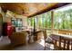Relaxing covered patio with a TV, retro refrigerator, and cozy seating, perfect for outdoor entertaining and leisure at 447 Lacy Rd, Canton, GA 30115
