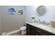 A modern powder room featuring a granite countertop, wainscotting, vanity, and a round mirror at 447 Lacy Rd, Canton, GA 30115
