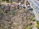 An aerial view shows empty land with many trees surrounded by houses at 1734 Summit Glen, Atlanta, GA 30329