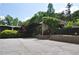 View of a modern brick house with lush landscaping, mature trees, and a spacious driveway at 1791 Harper Nw St # H, Atlanta, GA 30318