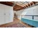 Bright loft area featuring hardwood floors, open ceiling beams, built in storage and unique metal railing detail at 1791 Harper Nw St # H, Atlanta, GA 30318