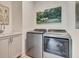 Convenient laundry room with stainless steel washer and dryer, sink, and gray cabinets at 250 4Th St, Fayetteville, GA 30214