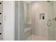 The neutral toned shower features a glass door, bench, built-in shampoo niche, and bronze fixtures at 250 4Th St, Fayetteville, GA 30214