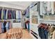 This walk-in closet has ample hanging space, built-in shelving, and an upholstered ottoman at 250 4Th St, Fayetteville, GA 30214