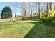 Large green backyard surrounded by mature trees and a wooden fence, providing privacy and a natural setting at 2593 Abbotts Glen Nw Dr, Acworth, GA 30101