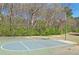 Community basketball court surrounded by a chain link fence and mature trees for recreational enjoyment at 2593 Abbotts Glen Nw Dr, Acworth, GA 30101