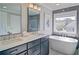Elegant bathroom with a soaking tub, double vanity, modern fixtures, and a bright window at 2593 Abbotts Glen Nw Dr, Acworth, GA 30101