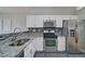 Well-lit kitchen featuring stainless steel appliances, white cabinets, and granite countertops at 2593 Abbotts Glen Nw Dr, Acworth, GA 30101