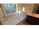 Bright bathroom featuring a soaking tub with a large window and a vanity with a white countertop at 4440 Cedar Bridge Walk, Suwanee, GA 30024