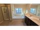 Well-lit bathroom with a glass shower, soaking tub under a window, and a double sink vanity at 4440 Cedar Bridge Walk, Suwanee, GA 30024