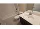 Bathroom with white tub, shower, single sink vanity with dark wood at 4440 Cedar Bridge Walk, Suwanee, GA 30024