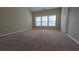 Primary bedroom featuring neutral colored carpet, walls and large windows for natural light at 4440 Cedar Bridge Walk, Suwanee, GA 30024