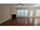 Open living room boasts gleaming hardwood floors and a cozy fireplace at 4440 Cedar Bridge Walk, Suwanee, GA 30024