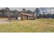 View of the home's rear exterior with a detached garage and wooden back deck at 5687 Highway 212, Covington, GA 30016