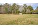 Large, level, grassy backyard with trees and metal shed at 5687 Highway 212, Covington, GA 30016