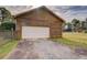 Spacious detached garage featuring a white garage door, matching wood siding, and a concrete driveway at 5687 Highway 212, Covington, GA 30016