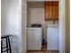 A functional laundry room with modern washer, dryer, and cabinet storage at 5687 Highway 212, Covington, GA 30016