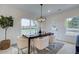Bright dining room with a contemporary chandelier, table, and view of the backyard at 113 Priestwood Ln, Acworth, GA 30102