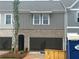 Two-story townhome featuring a gray-brick exterior with open garage, perfect for modern living at 113 Priestwood Ln, Acworth, GA 30102