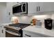 Close-up of a kitchen featuring stainless steel appliances, white cabinetry, and modern countertops at 113 Priestwood Ln, Acworth, GA 30102