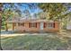 Charming brick ranch home with red shutters and a covered parking on a spacious lot at 2739 Council St, Lithonia, GA 30058