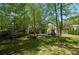 Inviting backyard with lush greenery, deck, stone fireplace and patio offers a perfect outdoor living space at 404 Queensbury Pl, Acworth, GA 30102