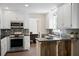 This kitchen features stainless appliances, white cabinetry, and a stylish backsplash at 404 Queensbury Pl, Acworth, GA 30102