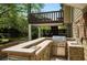 Outdoor kitchen with a built-in grill and stone accents, perfect for entertaining guests at 404 Queensbury Pl, Acworth, GA 30102