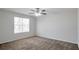 Bedroom featuring neutral walls, carpet, a ceiling fan, and a large window providing natural light at 5551 Panola Pl, Lithonia, GA 30058
