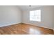 Spacious bedroom featuring wood floors, neutral walls, and a large window providing natural light at 5551 Panola Pl, Lithonia, GA 30058