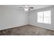 Bedroom featuring neutral walls, carpet, a ceiling fan, and a large window providing natural light at 5551 Panola Pl, Lithonia, GA 30058