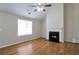 Inviting living room with hardwood floors, ceiling fan, fireplace and natural light from large windows at 5551 Panola Pl, Lithonia, GA 30058