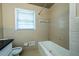 Bathroom featuring a standard bathtub with tile surround and a window for natural light at 2727 Whites Mill Ct, Decatur, GA 30034