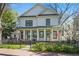 Charming two-story home featuring a well-manicured lawn and a welcoming front porch with stately columns and black framed windows at 273 Glenwood Se Ave # B, Atlanta, GA 30312