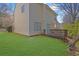 A backyard with a wooden deck, grassy area, and partial view of the home's exterior at 7176 Ravenwood Ln, Lithonia, GA 30038