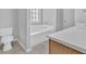 Clean bathroom featuring a soaking tub, tiled floor and a toilet at 7176 Ravenwood Ln, Lithonia, GA 30038