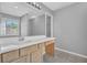 Bright bathroom with neutral walls, wood cabinets, and a large mirror at 7176 Ravenwood Ln, Lithonia, GA 30038