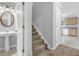Bathroom with pedestal sink, stairwell and view to the kitchen at 7176 Ravenwood Ln, Lithonia, GA 30038