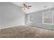 Large bedroom featuring neutral walls, ceiling fan, carpet, and two windows at 7176 Ravenwood Ln, Lithonia, GA 30038
