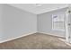 Cozy bedroom with a window offering natural light and neutral carpet at 7176 Ravenwood Ln, Lithonia, GA 30038
