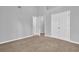 Spacious carpeted bedroom with neutral gray walls, bright lighting, and closet at 7176 Ravenwood Ln, Lithonia, GA 30038