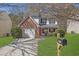 Charming two-story home with manicured lawn, brick accents and a lovely, blooming tree at 7176 Ravenwood Ln, Lithonia, GA 30038