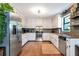 Bright eat-in kitchen showcases stainless steel appliances, granite counters, and white cabinetry and hardwood floors at 3582 Ontario Ct, Buford, GA 30519