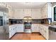 Bright eat-in kitchen features stainless steel appliances, granite counters, and white cabinetry at 3582 Ontario Ct, Buford, GA 30519