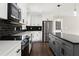 Beautiful kitchen with stainless steel appliances, white cabinets, gray island, and black subway tile backsplash at 3376 Irish Ln, Decatur, GA 30032